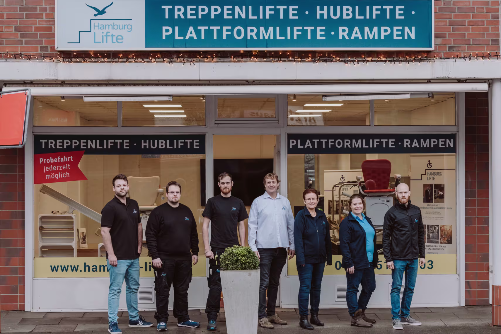 Team von Rhein-Mosel Lifte vor dem Ladengeschäft in Wellingsbüttel. Team von 7 Personen - 5 Männer und zwei Frauen
