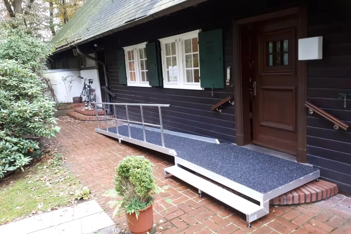 Rampe mit Podest im Außenbereich vor einem Haus seitlich verlaufend. Aufbau durch Rhein-Mosel Lifte.