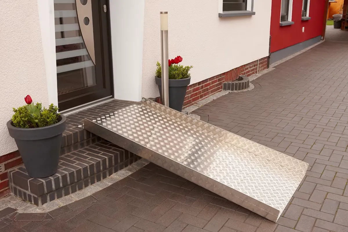 Klapprampe von Rhein-Mosel Lifte steht Aufgebaut vor einer Haustür um die Stufe davor zu überwinden