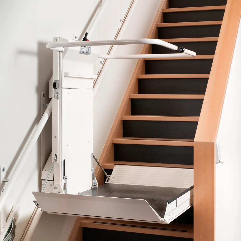 Ein Plattformlift in Fahrtposition in der Mitte der Treppe.